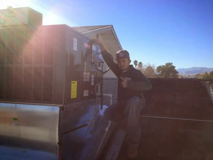 HVAC technician performing Air Duct Repair on a rooftop unit in Bath